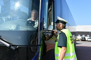 Inspektor transportu drogowego rozmawia z kierowcą kontrolowanego pojazdu.