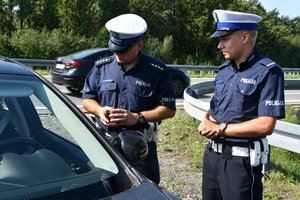 Policjanci kontrolują samochód podczas akcji Bezpieczny weekend - ostatni weekend wakacji.