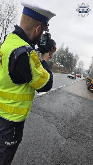 na zdjęciu umundurowany policjant prowadzący czynności kontroli drogowej