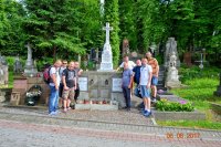 Grupa policjantów po cywilnemu stoi przy grobowcu