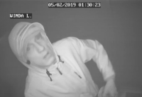 Czarno-białe zdjęcie - mężczyzna w kapturze patrzy w kamerę