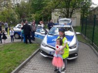 Dwie małe dziewczynki fotografują się na tle radiowozu