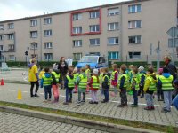 Dzieci biorą udział w zawodach, w tle radiowóz.