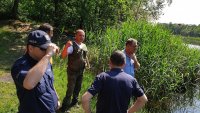Meżczyźni po cywilnemu i umundurowany policjant.