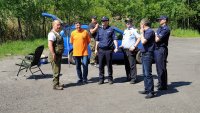 Mężczyźni po cywilnemu i policjanci pozują do zdjęcia