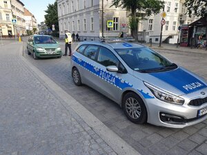 Umundurowany policjant kontroluje kierowcę.