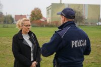 Policjant rozmawia z pracownicą szkoły