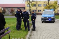 Policyjna narada - czterech policjantów, w tle radiowóz