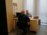 Policjant przy biurku przesłuchuje podejrzanego