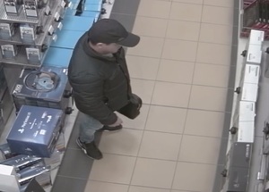 Mężczyzna w czapce z daszkiem w sklepie z RTV.
