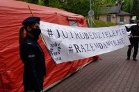 Policjanci trzymają duży transparent