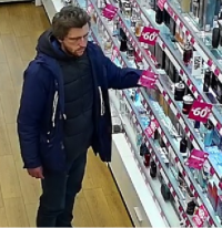 Mężczyzna przy półce z perfumami
