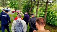 Policjanci i osoby cywilne w terenie zadrzewionym
