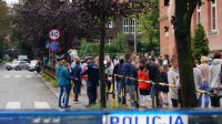 Policyjny &amp;quot;kogut&amp;quot; na pierwszym planie.W tle orzejscie dla pieszych gdzie policjant rozdaje odblaski dzieciom. Po prawej tłum dzieci i rodziców pod szkołą.