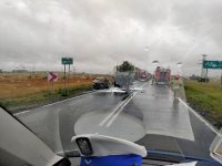 Zdjęcie wypadku z wnętrza policyjnego radiowozu. Na pierwszym planie czapka poliyjna. w tle za szyba droga a na niej rozbite dwa auta.