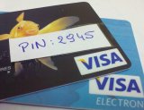 Dwie karty płatnicze Visa z naklejonym kodem PIN