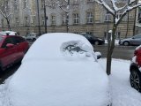 Osnieżony samochód na parkingu.