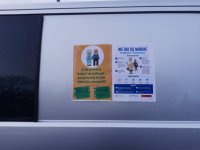 Dwa plakaty profilaktyczne naklejone na radiowóz.