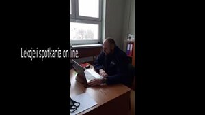 Policjant przy laptopie - prowadzi lekcje on line.
