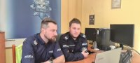 Dwaj policjanci przy monitorze komputera.