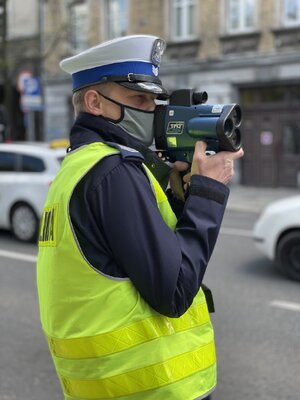 Policjant mierzący prędkość nadjeżdżających pojazdów.