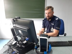 Policjant przy monitorze komputera.