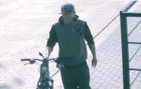 Mężczyzna w czapce z daszkiem prowadzący rower