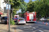 Pojazdy ratunkowe: policja, straż pożarna i pogotowie na ulicy w centrum miasta.