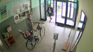 Mężczyzna prowadzi rower- wychodzi z budynku
