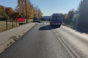 Ulica Poznańska w Pyskowicach. Po prawej widzimy karetkę pogotowia, po lewej na chodniki rozbity samochód osobowy, dalej po prawej samochód ciężarowy stojący w poprzek ulicy.