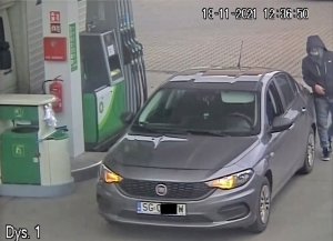 Fiat tipo z otwartą klapą bagażnika przy dystrybutorach na stacji benzynowej. Do samochodu wsiada młody mężczyzna w maseczce.