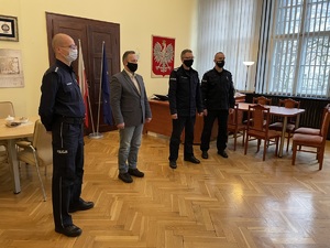 Czterej policjanci - komendanci stoją w gabinecie komendanta miejskiego.