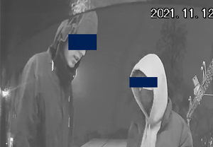 Dwaj młodzi mężczyźni w kapturach. Mają graficznie zasłonięte oczy.