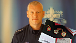 Policjant - dzielnicowy aspirant Artur Szałek i wklejona w jego zdjęcie legitymacja honorowego dawcy krwi oraz odznaki,