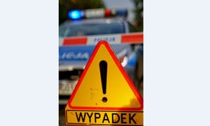 Na pierwszym planie znak ostrzegawczy - uwaga wypadek, z tyłu widać radiowóz