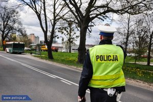 Policjant na ulicy daje znak do zatrzymania.