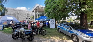 Policyjne stoisko, od prawej radiowóz, w głębi policyjny namiot i furgon policyjny, po lewej policyjna motorówka.