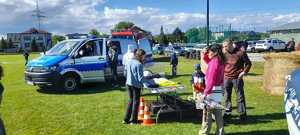 Policyjny radiowóz, policyjne stoisko i policjanci