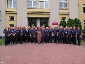 Policjanci i pracownicy cywilni pozujący - ustawieni przed budynkiem centu, szkolenia Policji w Legionowie.