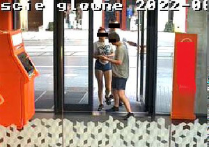 Na zdjęciu widzimy trzy osoby, dwóch mężczyzn i kobietę - wchodzących do pomieszczenia z bankomatem.