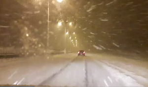 Na zdjęciu zaśnieżona autostrada wieczorową porą.