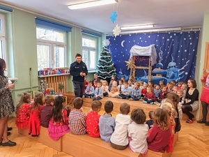 Na zdjęciu policjant rozmawiający z przedszkolakami.