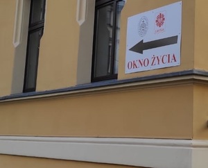 Na zdjęciu ściana budynku z oknami oraz tablica z napisem - okno życia.