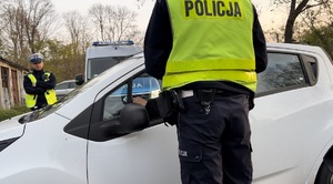 Na zdjęciu dwaj policjanci zatrzymali samochód - trwa kontrola trzeźwości kierowcy.