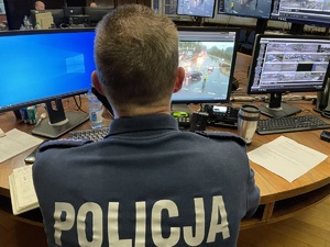 Na zdjęciu policjant siedzący przed monitorami.