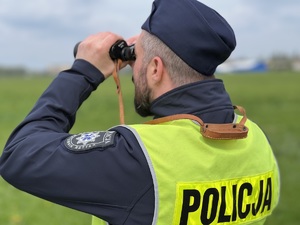 Na zdjęciu policjant obserwujący lotnisko.