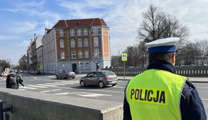 Na zdjęciu policjant drogówki obserwujący przejście dla pieszych.