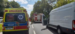 na zdjęciu widzimy stojące samochody służb ratunkowych i białego busa na środku drogi przed wypadkiem.