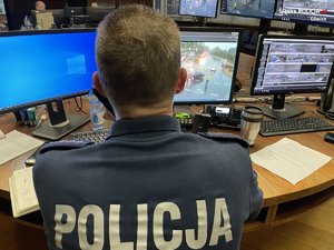 Policjant patrzący w ekrany monitoringu