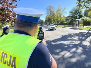 Na zdjęciu policjant ruchu drogowego z miernikiem prędkości.